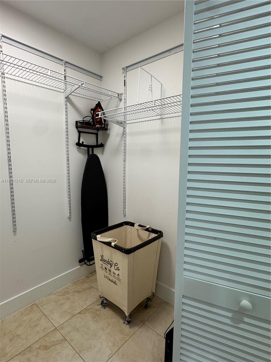 41 Southeast 5th Street, Unit 2305 Miami, FL 33131 - Photo 20 of 56 a room with a refrigerator and white cabinets