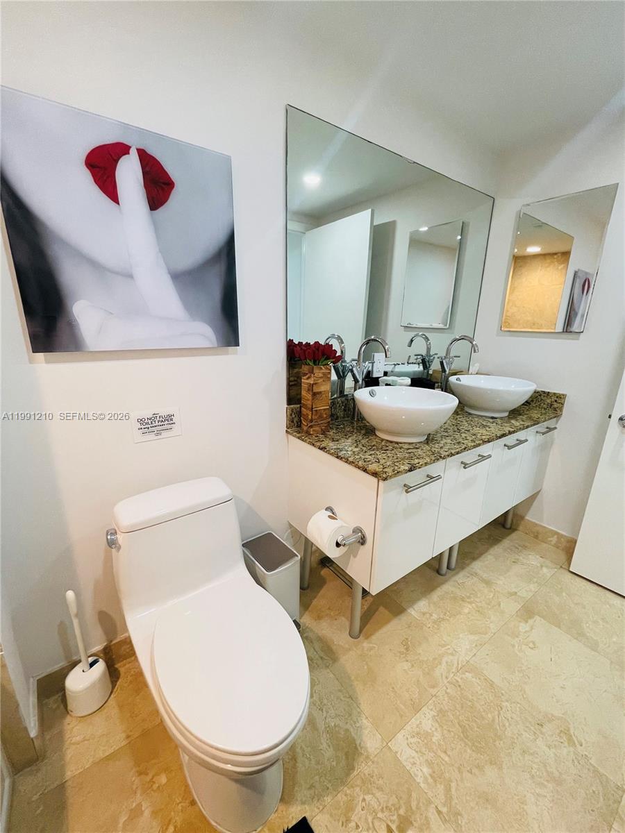 41 Southeast 5th Street, Unit 2305 Miami, FL 33131 - Photo 27 of 56 a bathroom with a sink and a mirror
