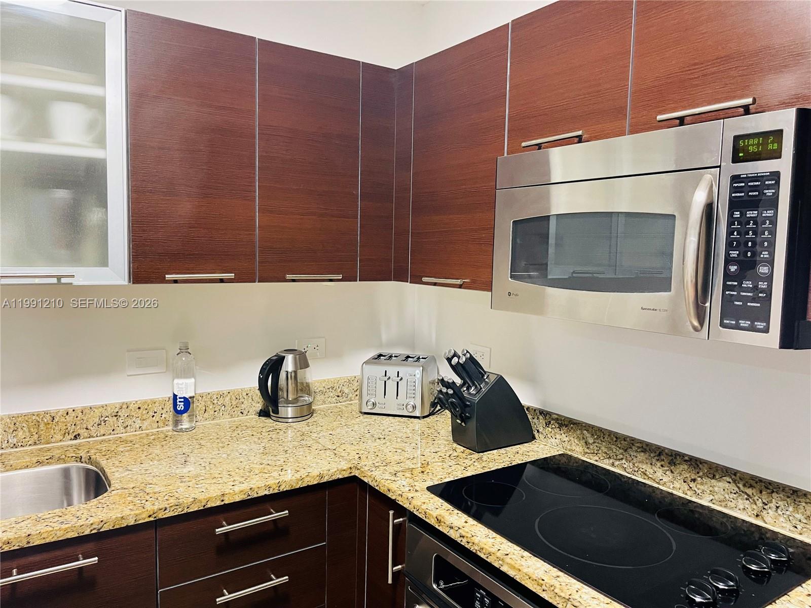 41 Southeast 5th Street, Unit 2305 Miami, FL 33131 - Photo 30 of 56 a kitchen with a sink and cabinets