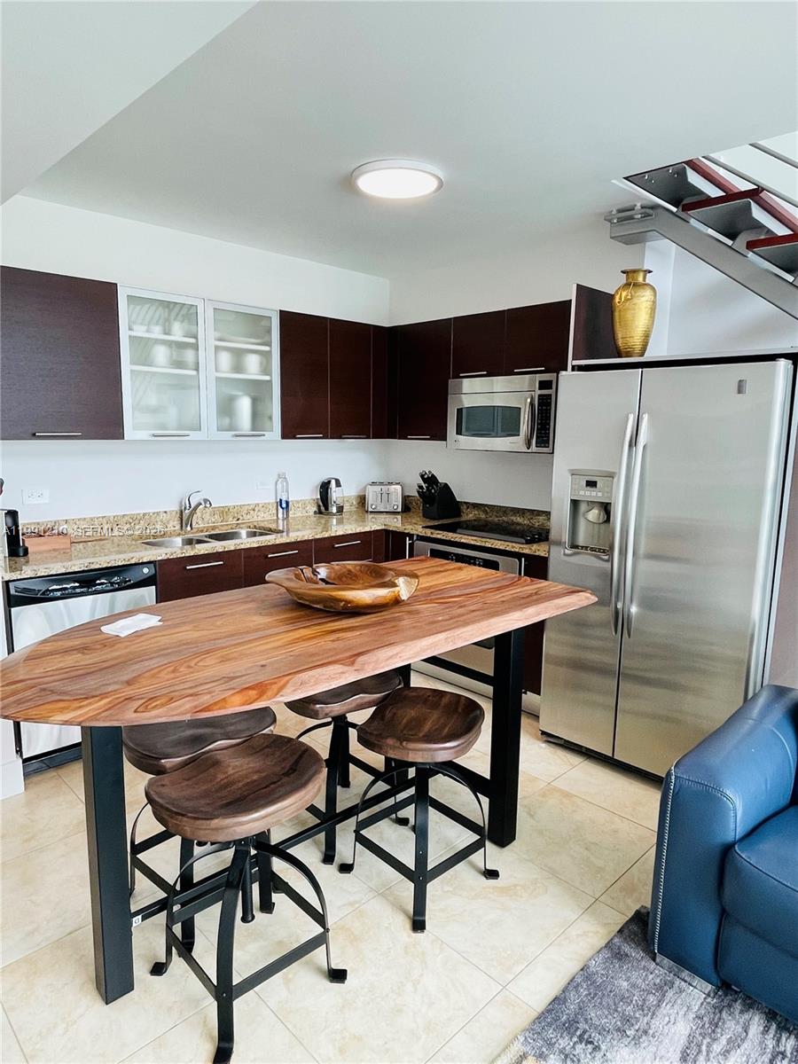41 Southeast 5th Street, Unit 2305 Miami, FL 33131 - Photo 8 of 56 a kitchen with stainless steel appliances kitchen island granite countertop a sink and cabinets