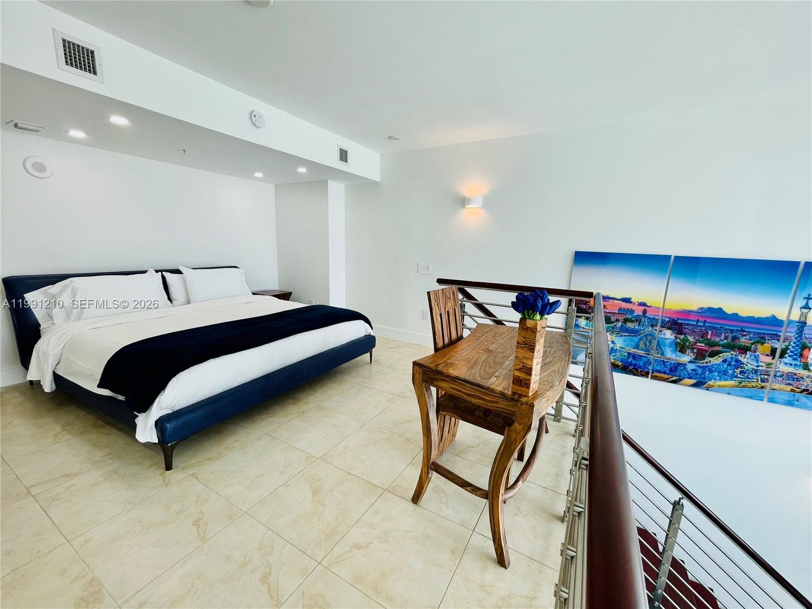 41 Southeast 5th Street, Unit 2305 Miami, FL 33131 - Photo 10 of 56 a bedroom with a bed and a table in it