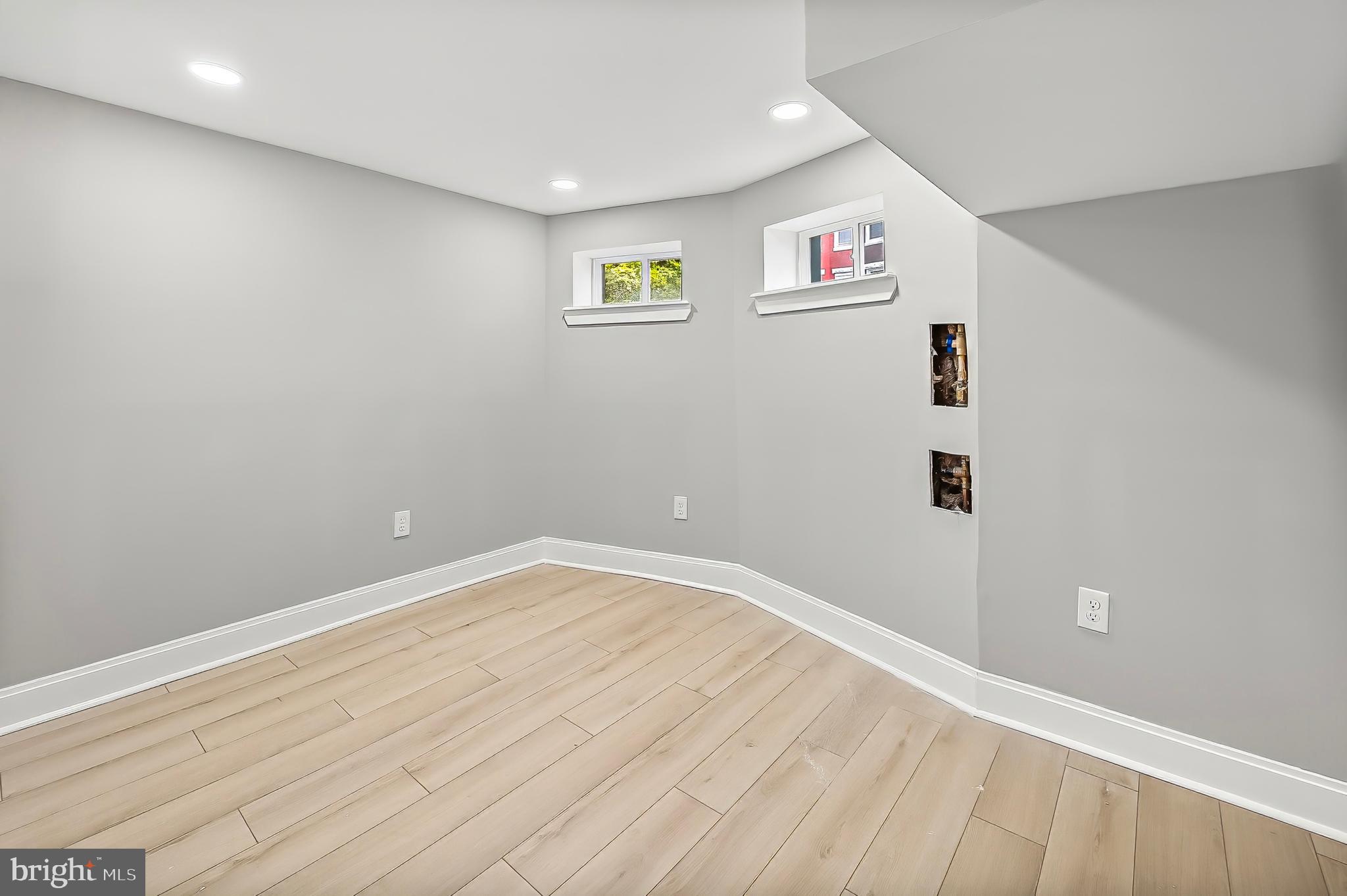 539 East 23rd Street Baltimore, MD 21218 - Photo 22 of 29 an empty room with wooden floor and windows