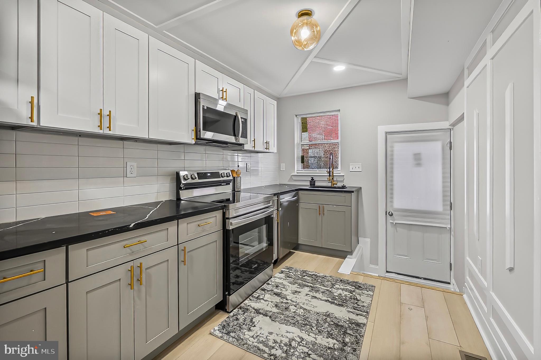 539 East 23rd Street Baltimore, MD 21218 - Photo 7 of 29 a kitchen with white cabinets and appliances