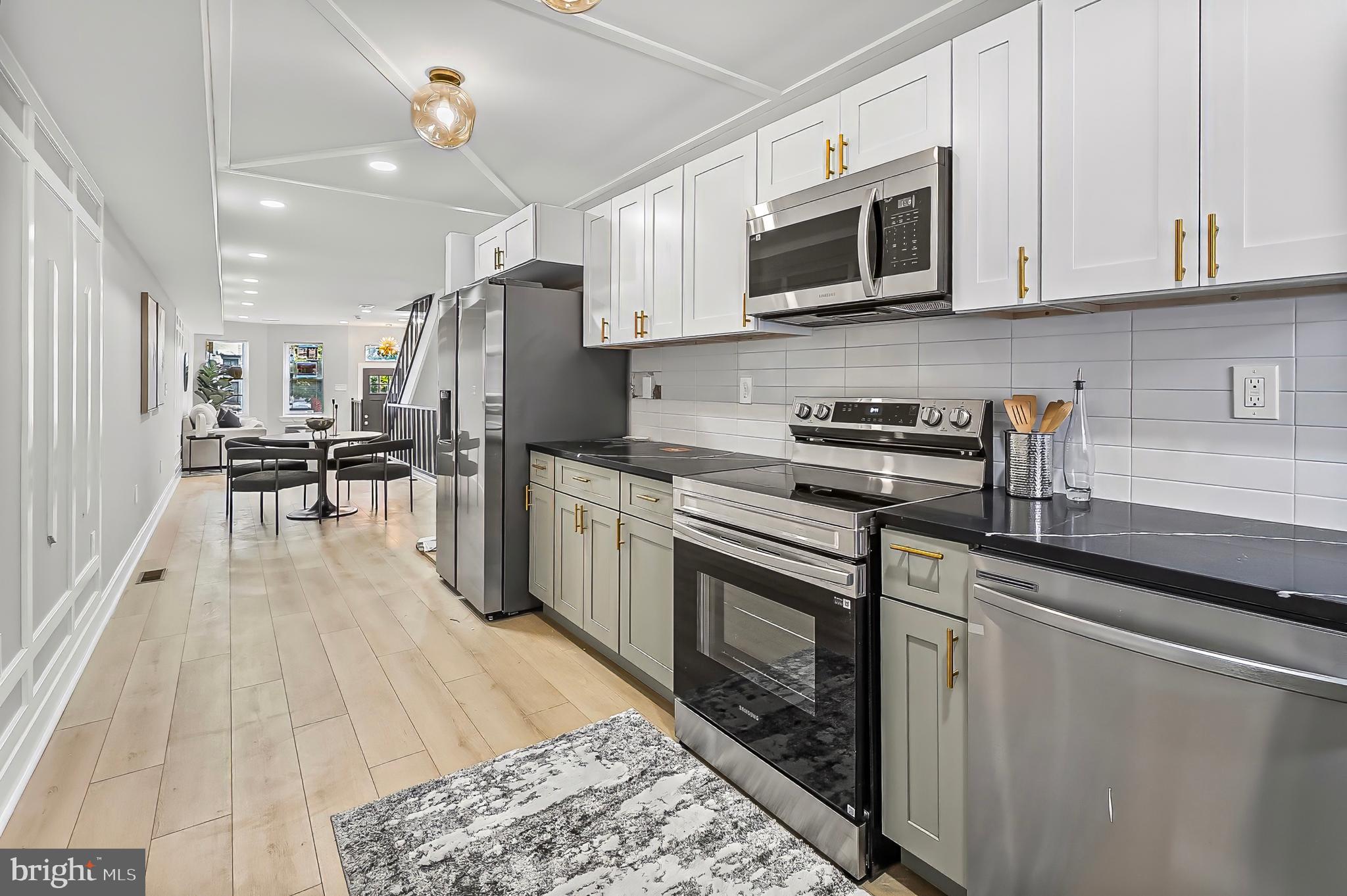 539 East 23rd Street Baltimore, MD 21218 - Photo 8 of 29 a kitchen with stainless steel appliances granite countertop a stove a sink and a microwave