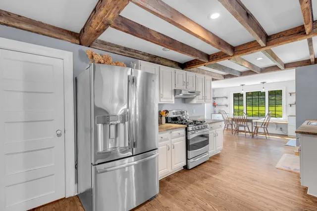a kitchen with granite countertop a refrigerator and wooden floor