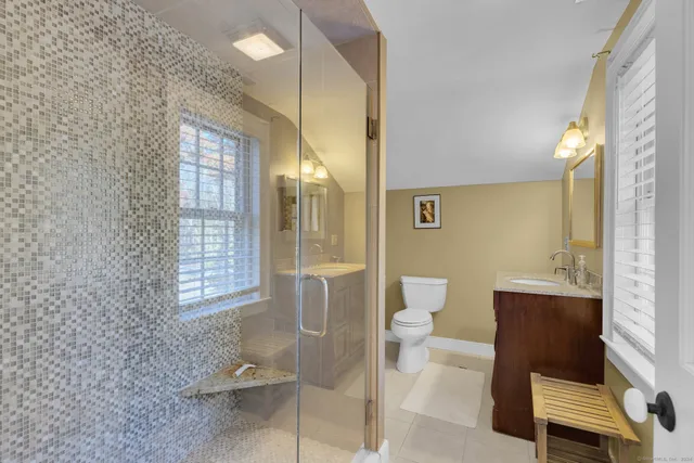 a bathroom with a granite countertop sink a toilet and a mirror