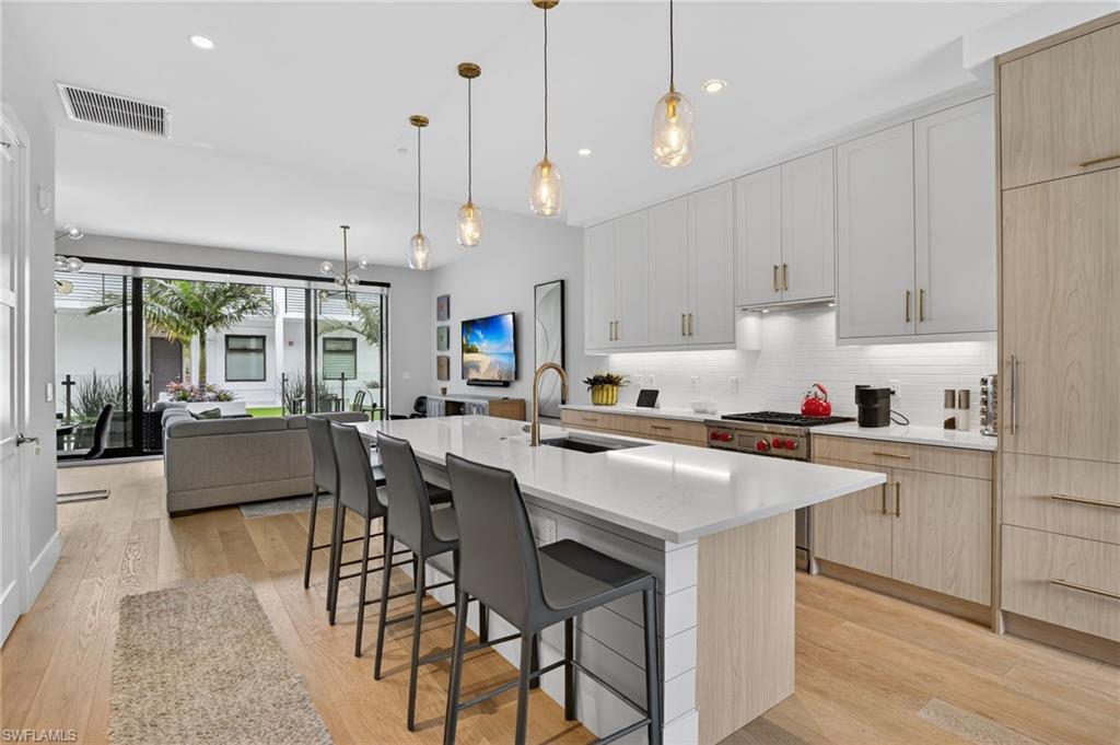 850 Central Avenue, Unit 208 Naples, FL 34102 - Photo 1 of 44 a kitchen that has a lot of cabinets in it with stainless steel appliances granite countertop a stove a sink a oven and white cabinets with wooden floor