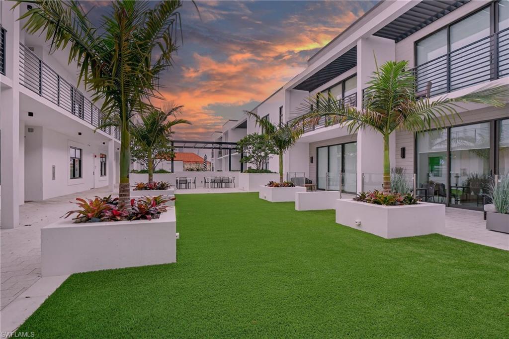 850 Central Avenue, Unit 208 Naples, FL 34102 - Photo 11 of 44 a front view of a house with a garden and yard
