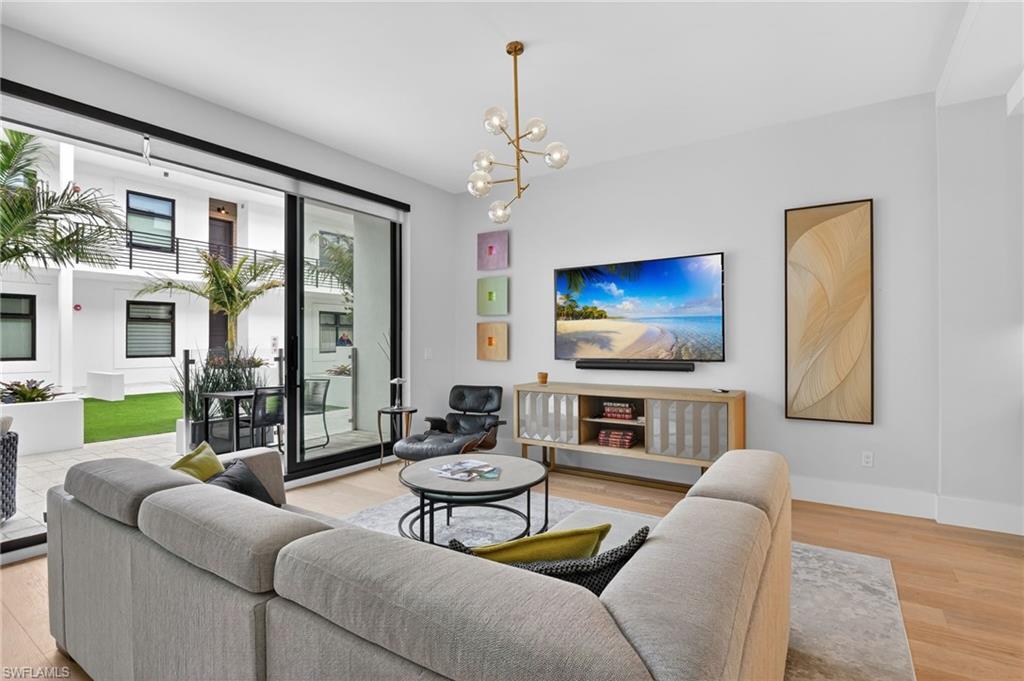 850 Central Avenue, Unit 208 Naples, FL 34102 - Photo 15 of 44 a living room with furniture and a flat screen tv