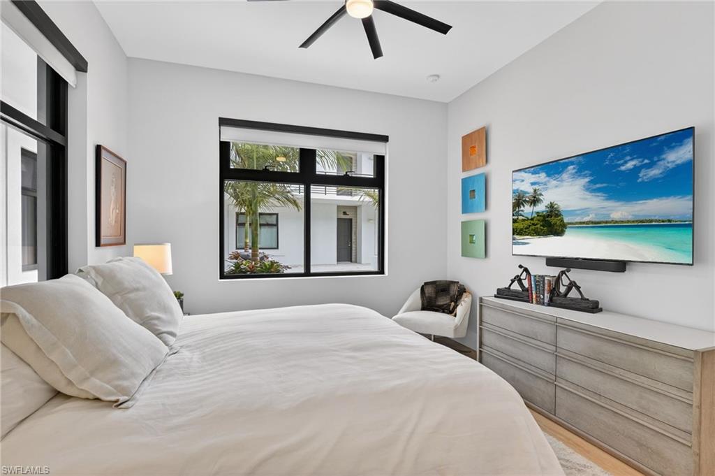 850 Central Avenue, Unit 208 Naples, FL 34102 - Photo 27 of 44 a bedroom with a large bed and a flat screen tv