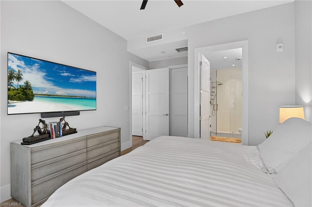 850 Central Avenue, Unit 208 Naples, FL 34102 - Photo 28 of 44 a bedroom with a bed and a flat screen tv