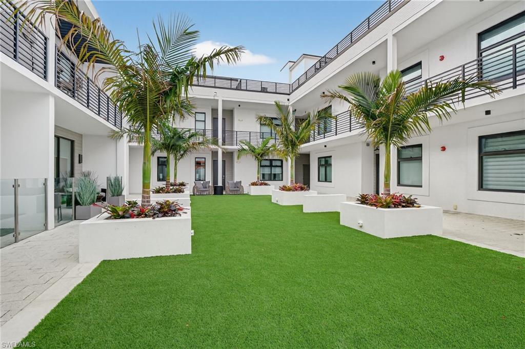 850 Central Avenue, Unit 208 Naples, FL 34102 - Photo 43 of 44 a front view of a house with a yard and potted plants