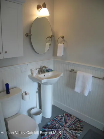 a bathroom with a sink toilet and a mirror