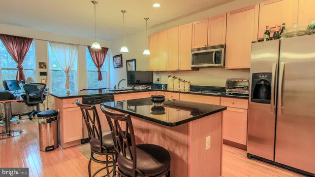 a kitchen with stainless steel appliances granite countertop a sink a stove and a refrigerator