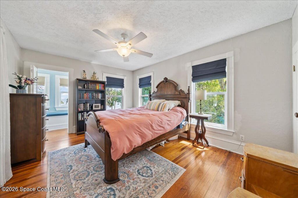 1110 Riverside Drive Titusville, FL 32780 - Photo 27 of 50 a bedroom with a bed and a bookshelf with wooden floor