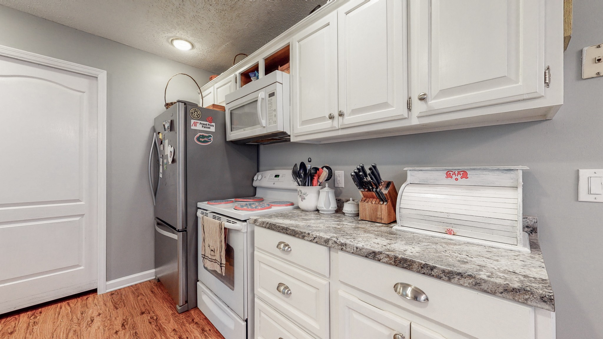 1081 Meeks Cemetery Road Burns, TN 37029 - Photo 21 of 45 a kitchen with stainless steel appliances granite countertop a refrigerator and white cabinets
