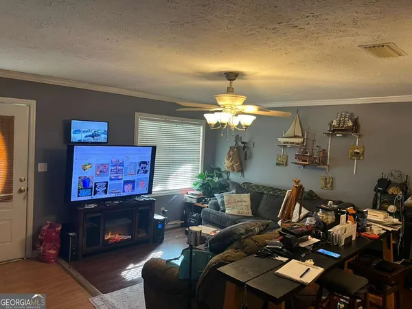 a living room with furniture a flat screen tv and a fireplace