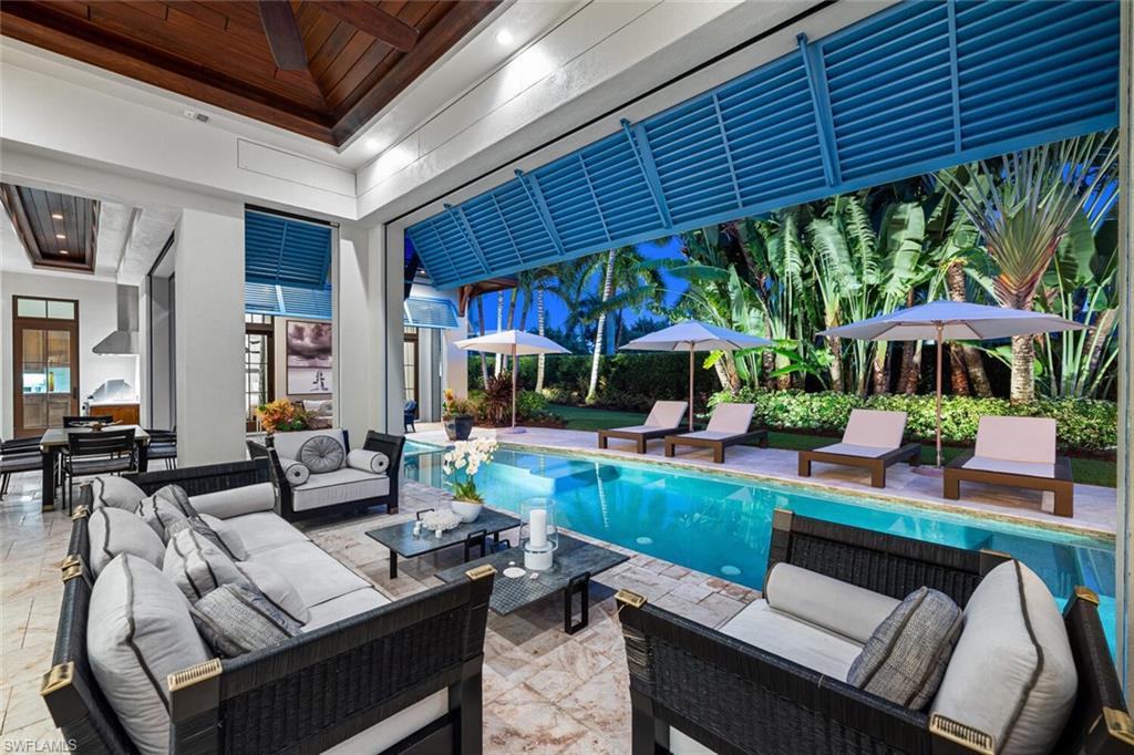 2284 Crayton Road Naples, FL 34103 - Photo 15 of 34 a outdoor living space with patio furniture and a fireplace