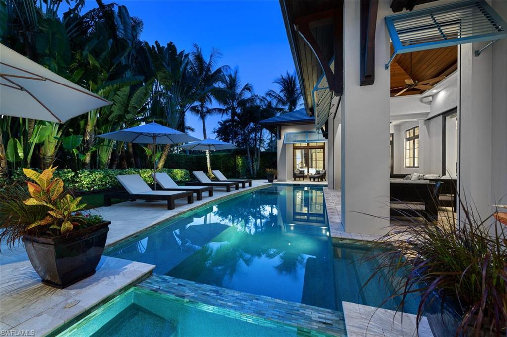 2284 Crayton Road Naples, FL 34103 - Photo 17 of 34 a view of a swimming pool with potted plants