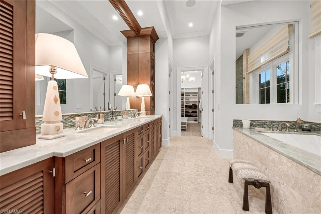 2284 Crayton Road Naples, FL 34103 - Photo 25 of 34 a spacious bathroom with a granite countertop sink mirror and a