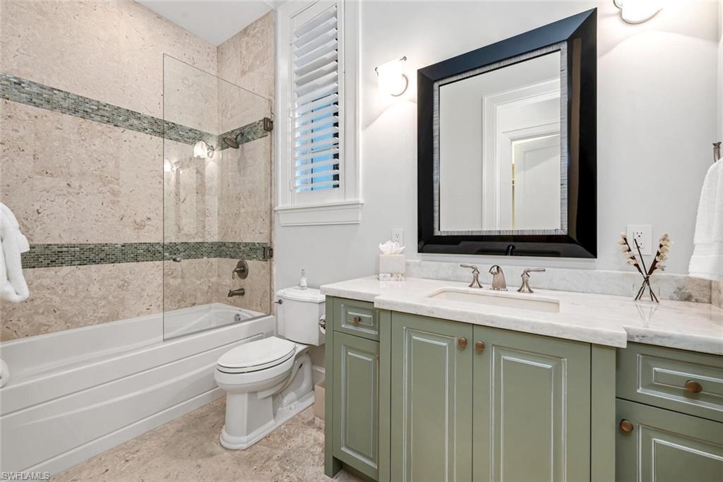 2284 Crayton Road Naples, FL 34103 - Photo 31 of 34 a bathroom with a toilet sink and mirror