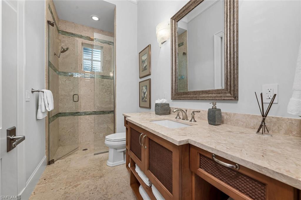 2284 Crayton Road Naples, FL 34103 - Photo 33 of 34 a bathroom with a granite countertop sink a toilet and shower