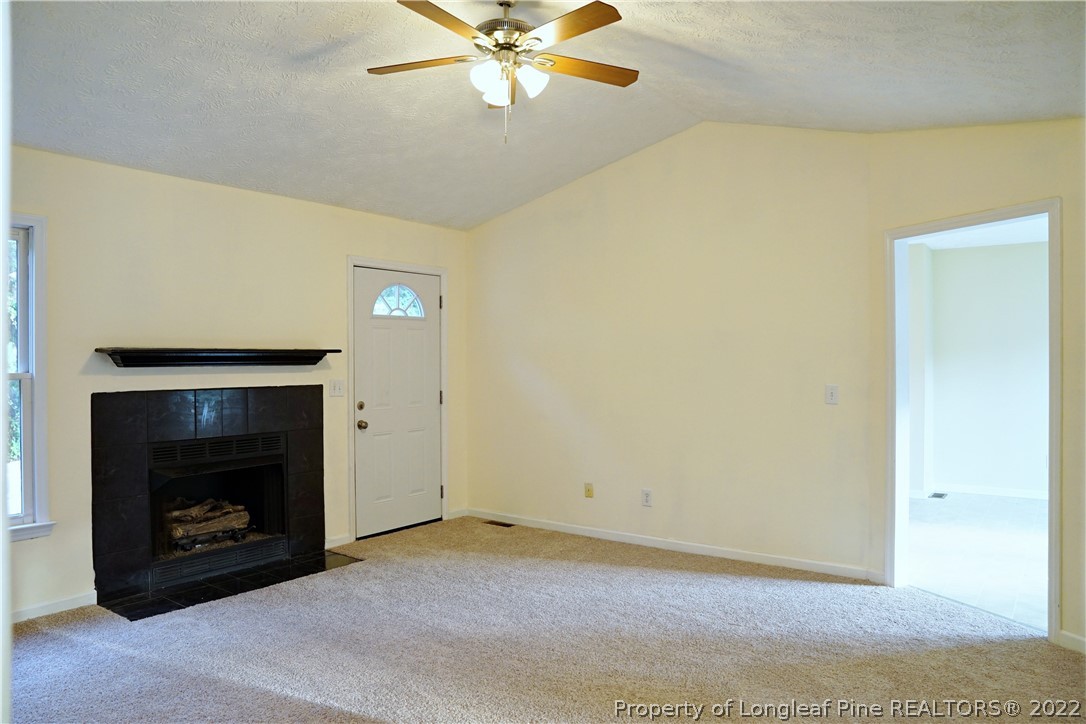 2029 Ashton Road Fayetteville, NC 28304 - Photo 15 of 37 a view of an empty room with chandelier fan and fire place