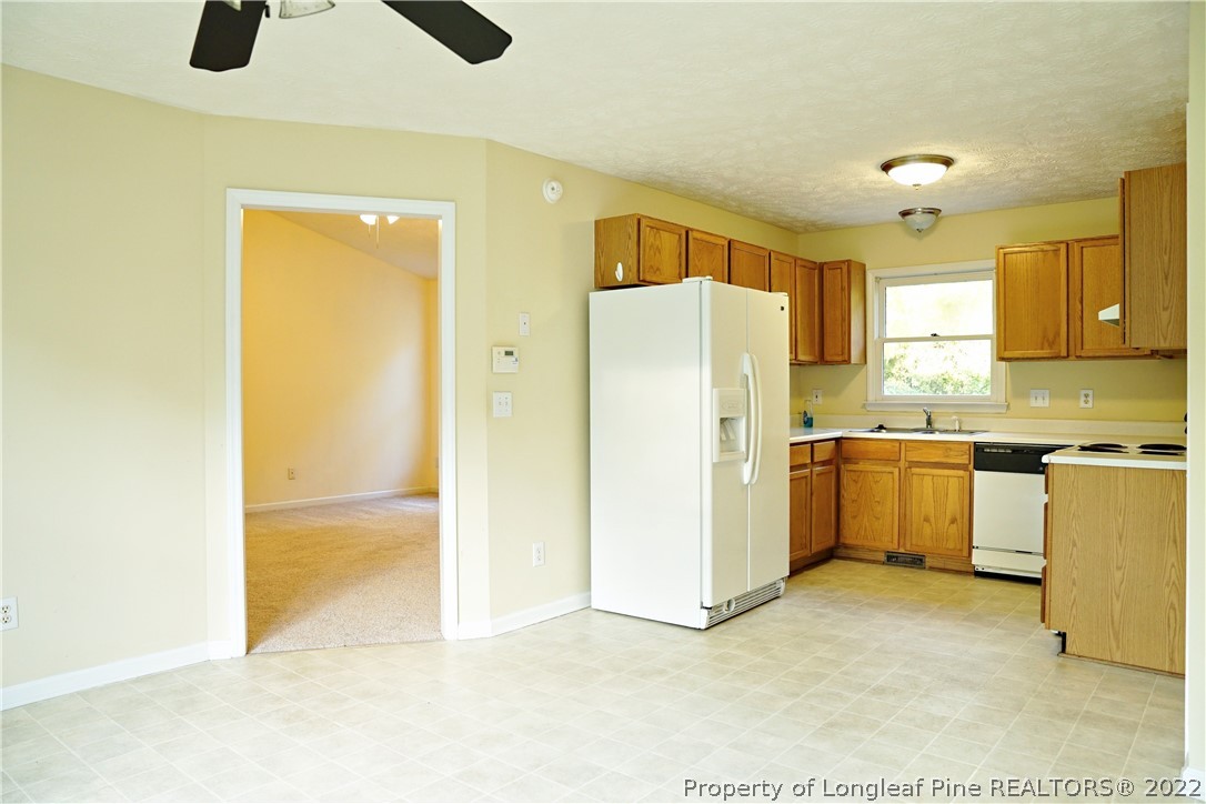 2029 Ashton Road Fayetteville, NC 28304 - Photo 35 of 37 a kitchen with a refrigerator a stove top oven a sink and dishwasher