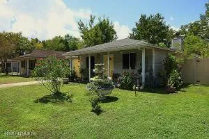 a view of a house with backyard garden and trees