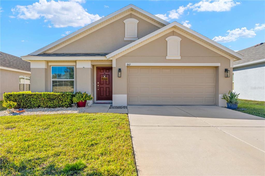 a front view of a house with a yard and garage