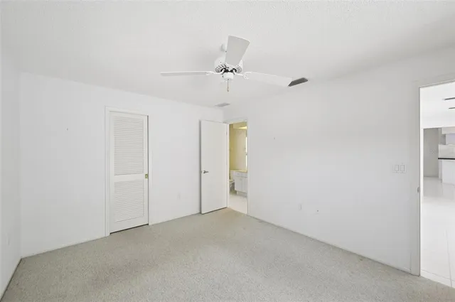 an empty room with a ceiling fan and a window