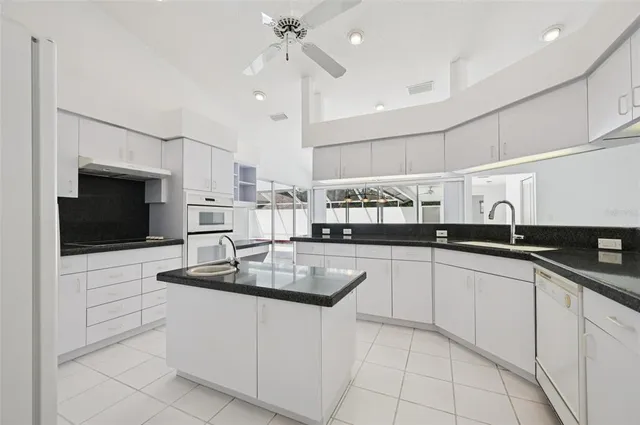 a kitchen with stainless steel appliances granite countertop a sink a stove and cabinets