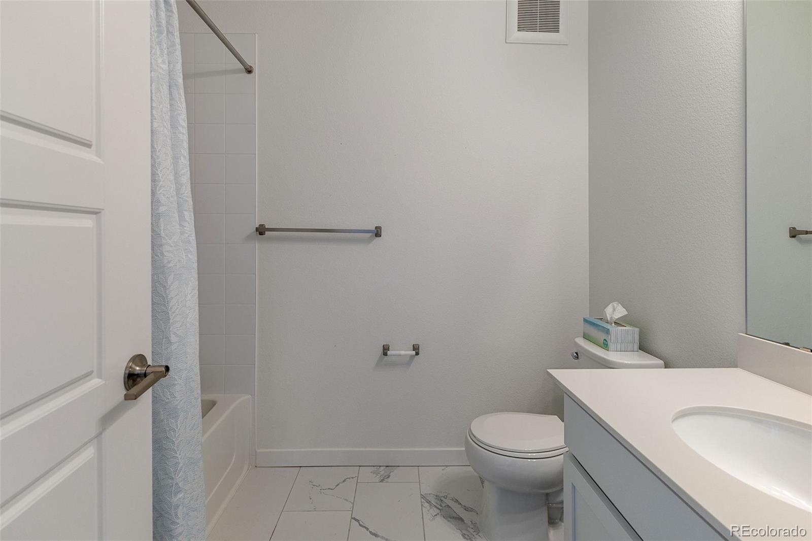 9287 Twenty Mile Road, Unit 401 Parker, CO 80134 - Photo 15 of 44 a white toilet sitting next to a bathroom sink