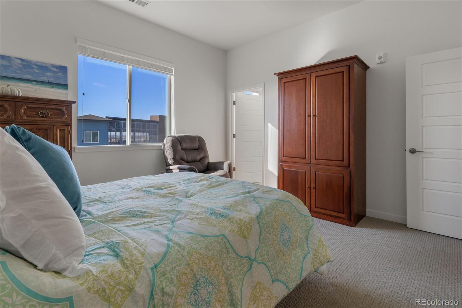 9287 Twenty Mile Road, Unit 401 Parker, CO 80134 - Photo 18 of 44 a bedroom with a bed and a window