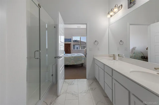 a en suite bathroom with a double vanity sink and a mirror