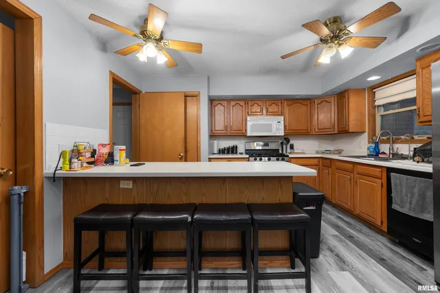 a large kitchen with kitchen island a sink a stove and a dining table