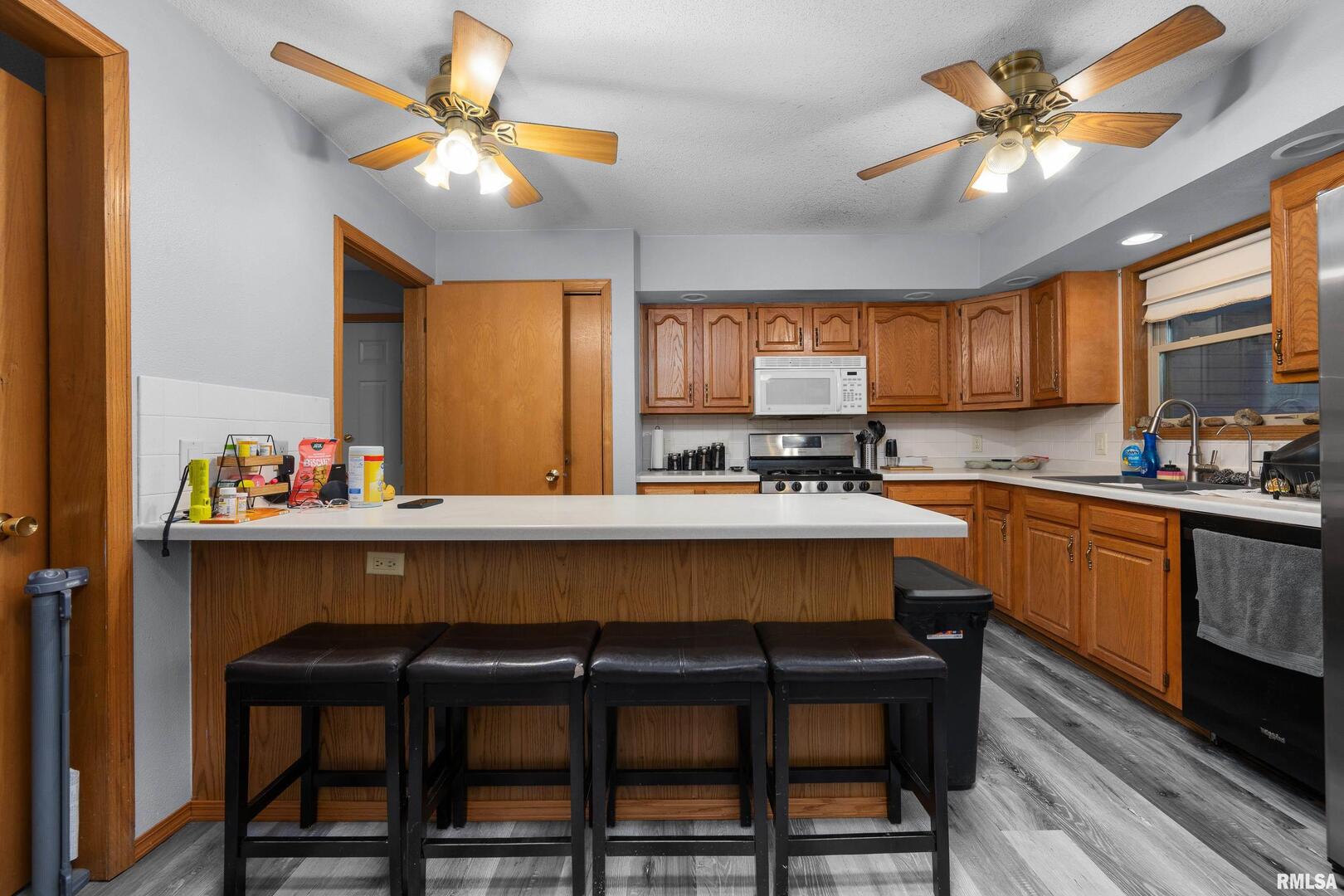 1231 90th Street Joy, IL 61260 - Photo 20 of 38 a kitchen with a dining table chairs refrigerator and cabinets