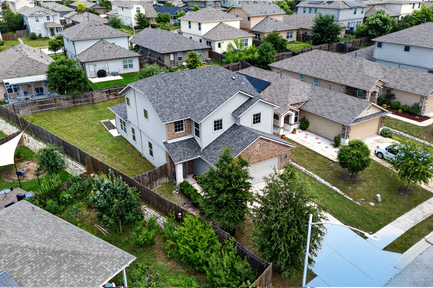 2006 Grow Lane Austin, TX 78754 - Photo 29 of 40 An aerial perspective reveals a two-story residence with a well-maintained lawn, privacy fencing, and mature landscaping.