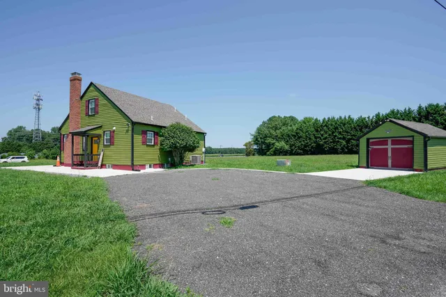 an empty room with wooden floor a fireplace and a window