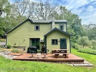 a view of backyard of house with outdoor seating and green space