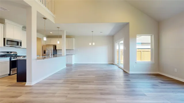 a view of kitchen with kitchen island wooden floor center island and stainless steel appliances