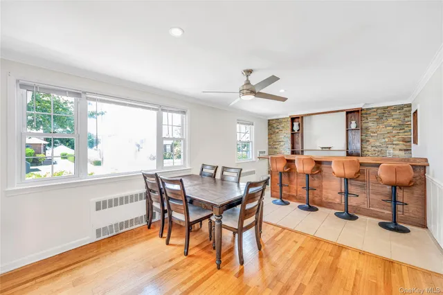 a view of a a dining room with furniture window and wooden floor