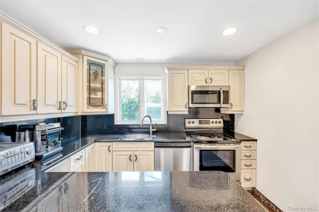 a kitchen with stainless steel appliances granite countertop a sink stove and cabinets