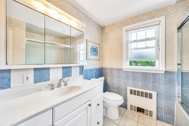 a bathroom with a sink a toilet and a window