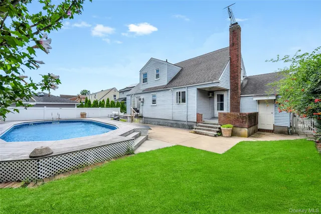 a swimming pool with outdoor seating and yard