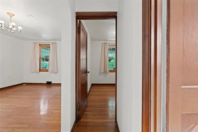 a view of a hallway with wooden floor and closet