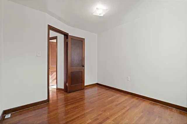 an empty room with wooden floor and closet