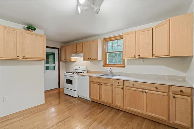 a kitchen with white cabinets sink and window