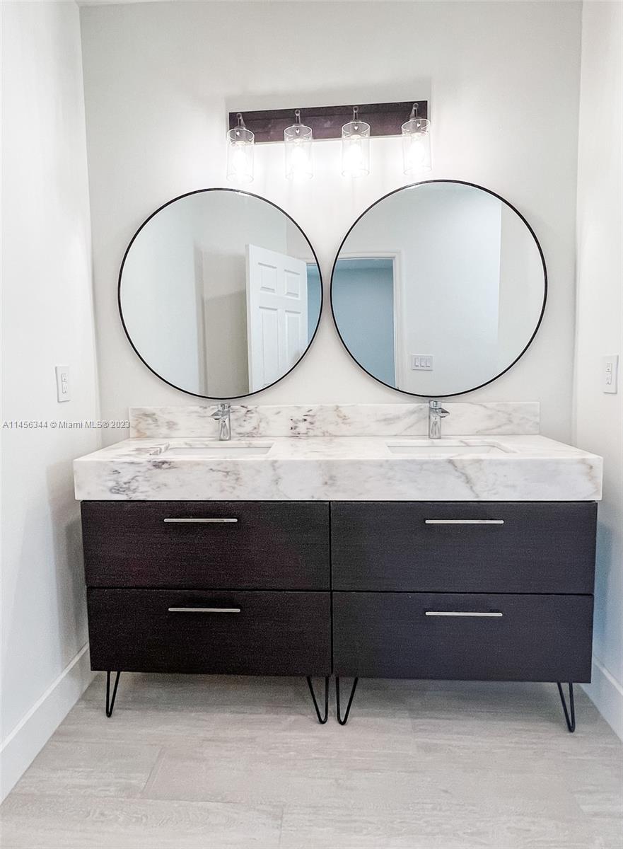 Collier City Pompano Beach, FL 33069 - Photo 12 of 28 a bathroom with a sink a mirror and a mirror
