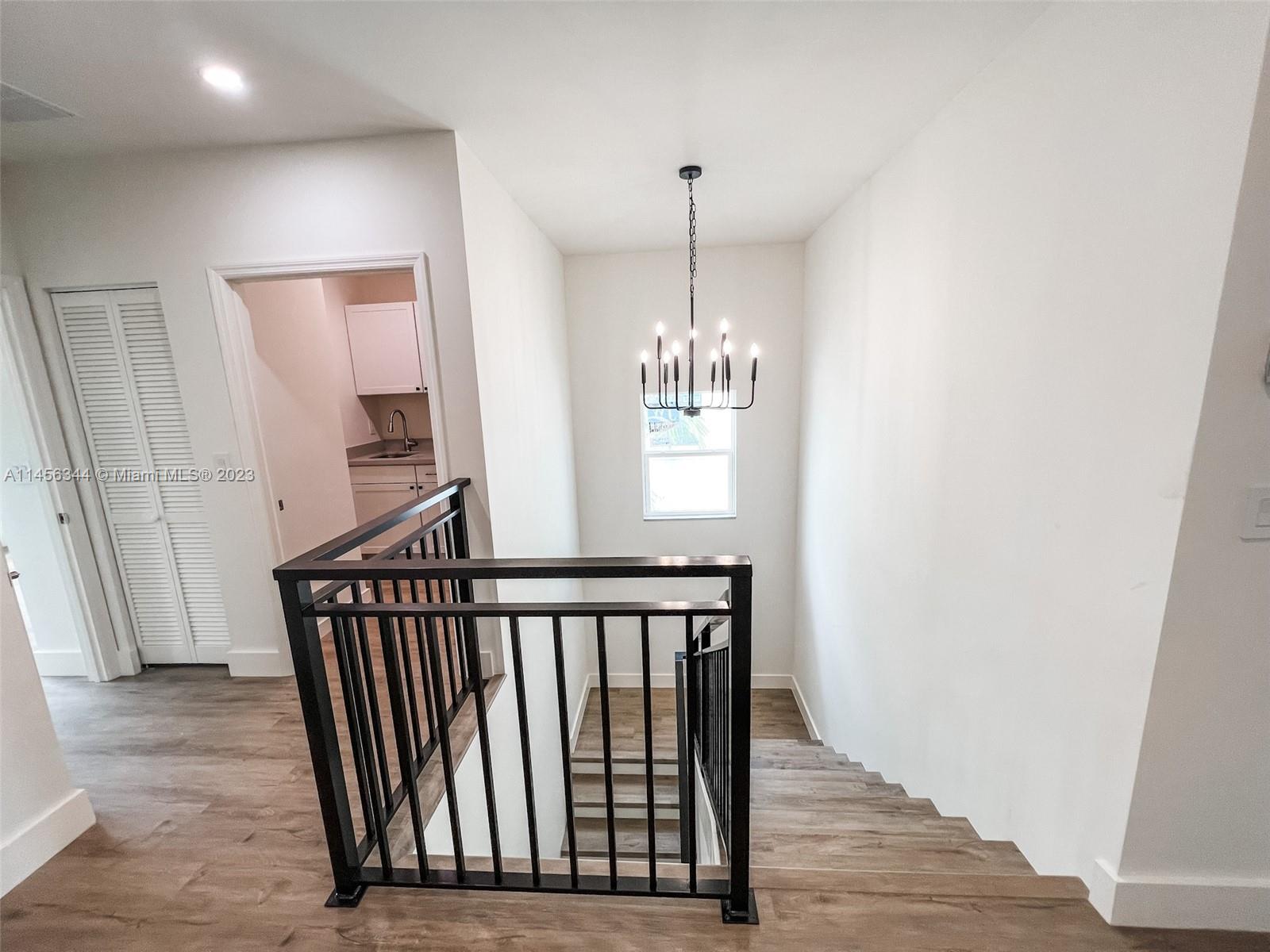 Collier City Pompano Beach, FL 33069 - Photo 13 of 28 a view of a hallway with wooden floor and stairs